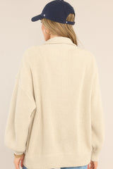 Back view of  this jacket that features a functional full zipper, a turtleneck, cozy knit material, and an oversized fit.