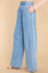 Side view of these pants that feature a high rise waist, a functional zipper, four functional pocket detailing, and a wide leg with side slits. 