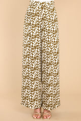 Front view of these pants that showcase the pattern of the fabric in shades of green and ivory.