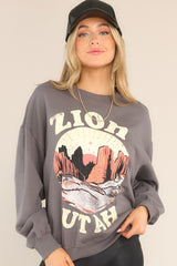 Close up view of this sweatshirt that features a ribbed crew neckline, dropped shoulders, a Zion graphic, ribbed cuffed long sleeves, and a ribbed hemline.