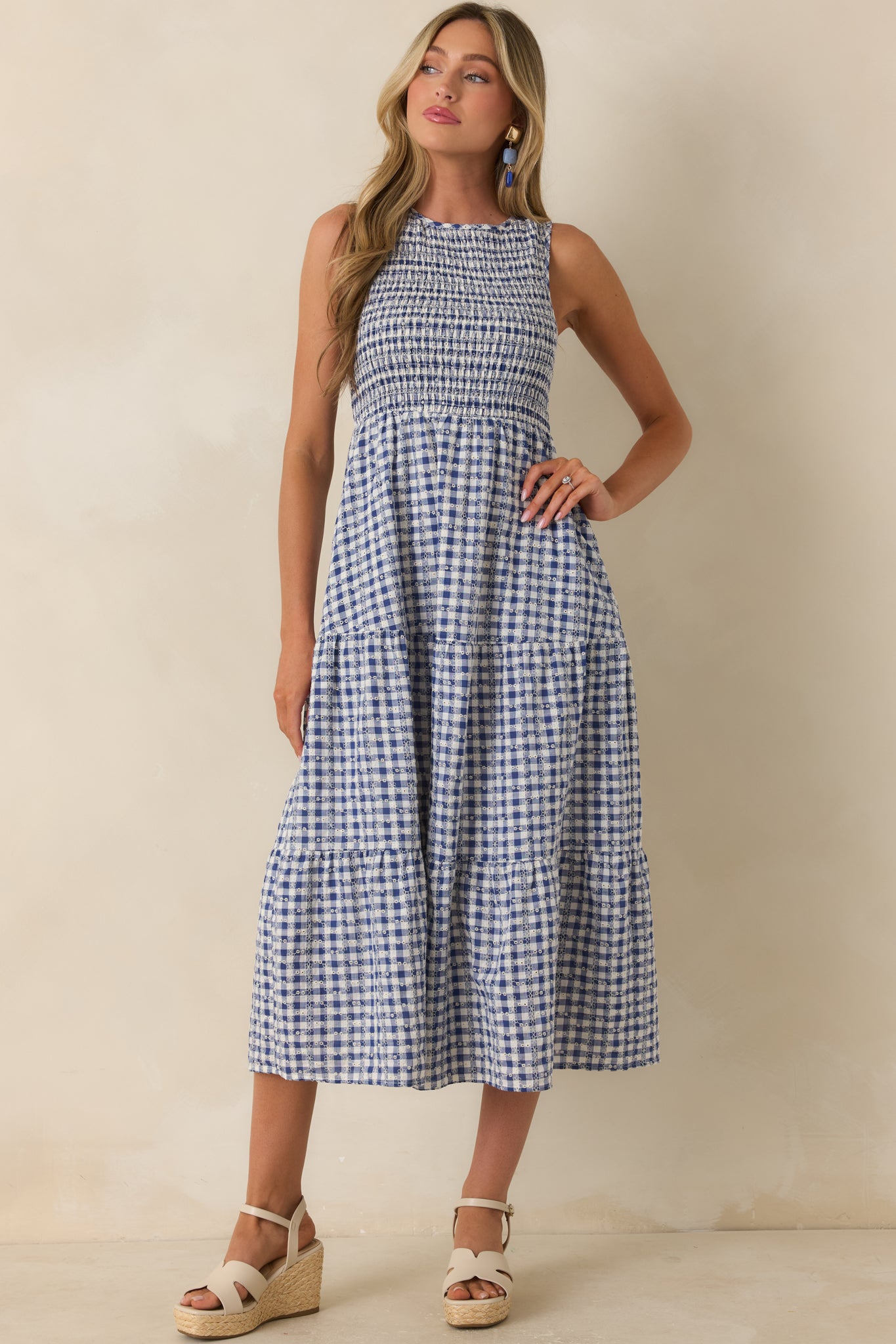 Midi-length gingham dress featuring structured smocking at the bust and airy skirt movement.