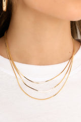 This gold necklace features 3 chains varying in length, and lobster claw clasp.