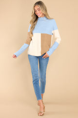 Full body view of this sweater that features a color block design in shades of blue, ivory, and brown.