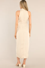Back view of this dress that features a high cowl neckline, a zipper down the back, a wrap-like design with a self-tie feature at the waist, and a front slit.