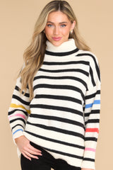 Front view of this sweater that features red, orange, blue, yellow, and pink stripes along the sleeves.