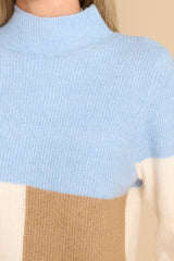 Close up view of this sweater that features a mock neckline, a color block design and a ribbed material. 