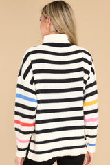 Back view of this sweater that features a turtleneck, an all-over striped pattern, side slits, and cuffed long sleeves.