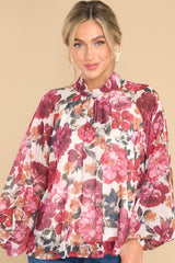 Front view of this top that showcases a floral print in shades of red, pink, orange, and green.