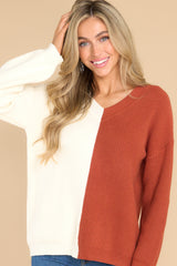 Front view of this sweater that features a v-neckline, ribbed detailing throughout, and a two tone color blocking.