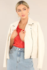 Ecru, vegan leather moto jacket, with rhodium detailing and an offset zipper up the front right hand side of the body.
