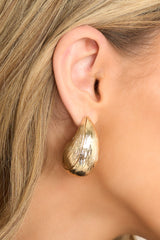 These earrings feature gold hardware, a textured geometric shape, and secure post backings.