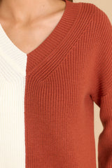 Close up view of this sweater that features a v-neckline, ribbed detailing throughout, and a two tone color blocking.
