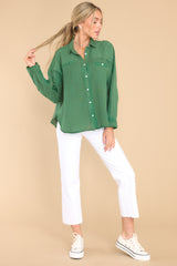 This green top features a collar neckline, button down bodice, and one front functional pocket.