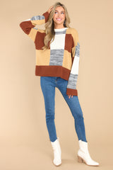 Full body view of this sweater that features a crew neckline, patchwork design, and a cozy oversized fit.