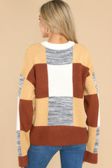 Back view of this sweater that features a crew neckline, patchwork design, and a cozy oversized fit.