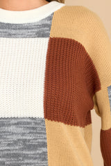 Close up view of this sweater that features a crew neckline, patchwork design, and a cozy oversized fit.
