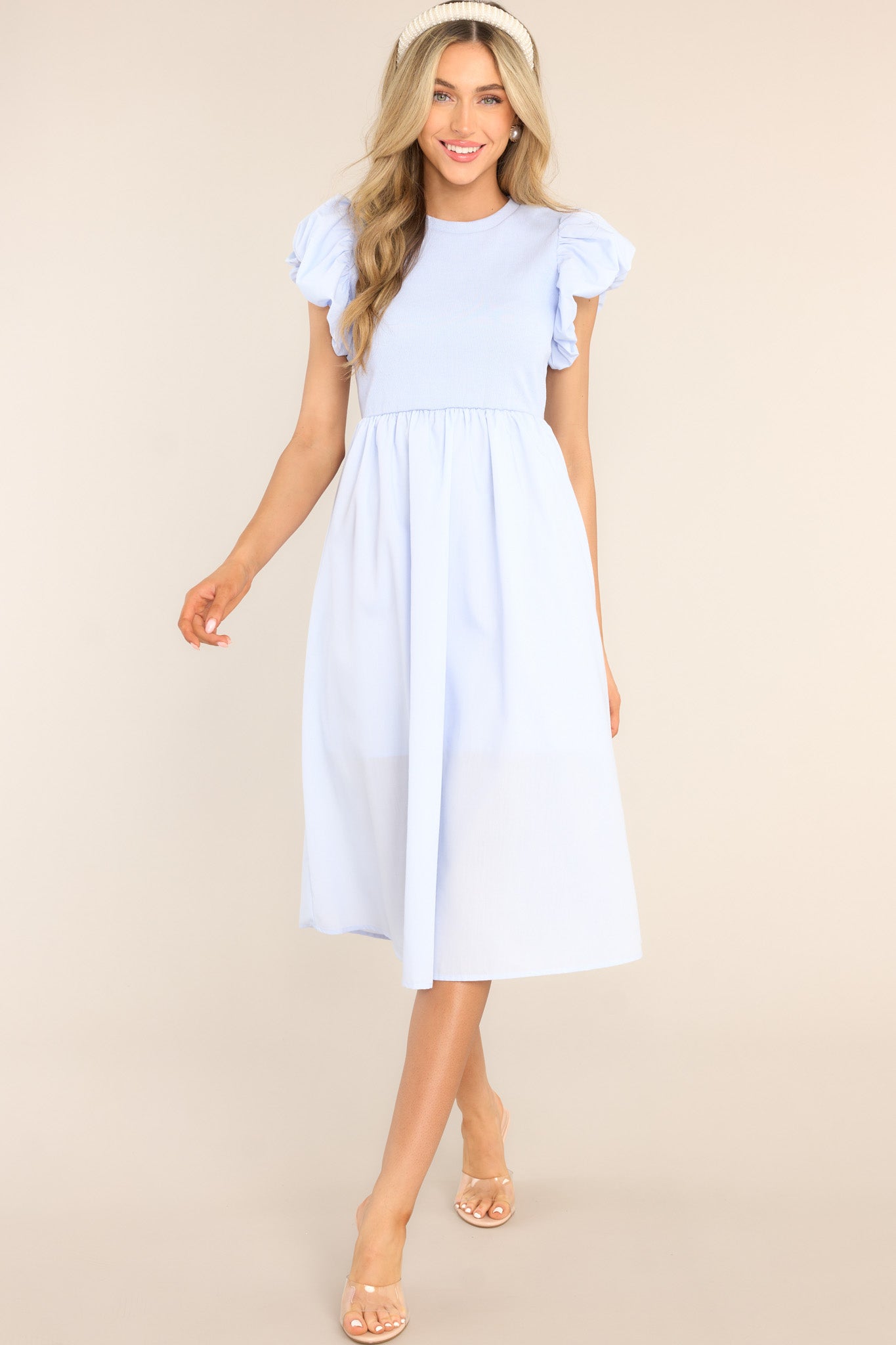 Front view of this dress that features a short puff sleeves, ribbed fabric throughout the top, functional pockets, and midi length.