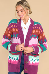 Front view of  this cardigan that features a v-neckline, drop shoulders, four functional buttons down the front, two front pockets, cuffed sleeves, an intricate jacquard pattern, and a soft knit material throughout.