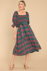 Front, full body photo of stunning green and red plaid midi dress, featuring a smocked bust, self tie belt, and square neckline. 