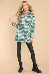 This green top features a collared neckline, buttons down the front, and a functional pocket at the bust.