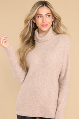 Front view of this sweater that features a cowl turtle neckline, long sleeves with ribbed cuffs, and a bottom hem that tapers in around the hips.
