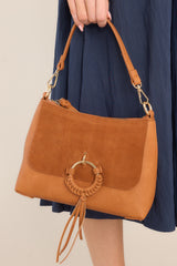 Front view of this bag that features gold hardware, zipper closure, comes with two detachable straps, has mixed textures, and a statement ring in the front.