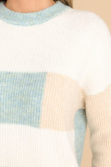 Close up view of this striped sweater that features a striped design, ribbed cuffs, and a soft fabric.