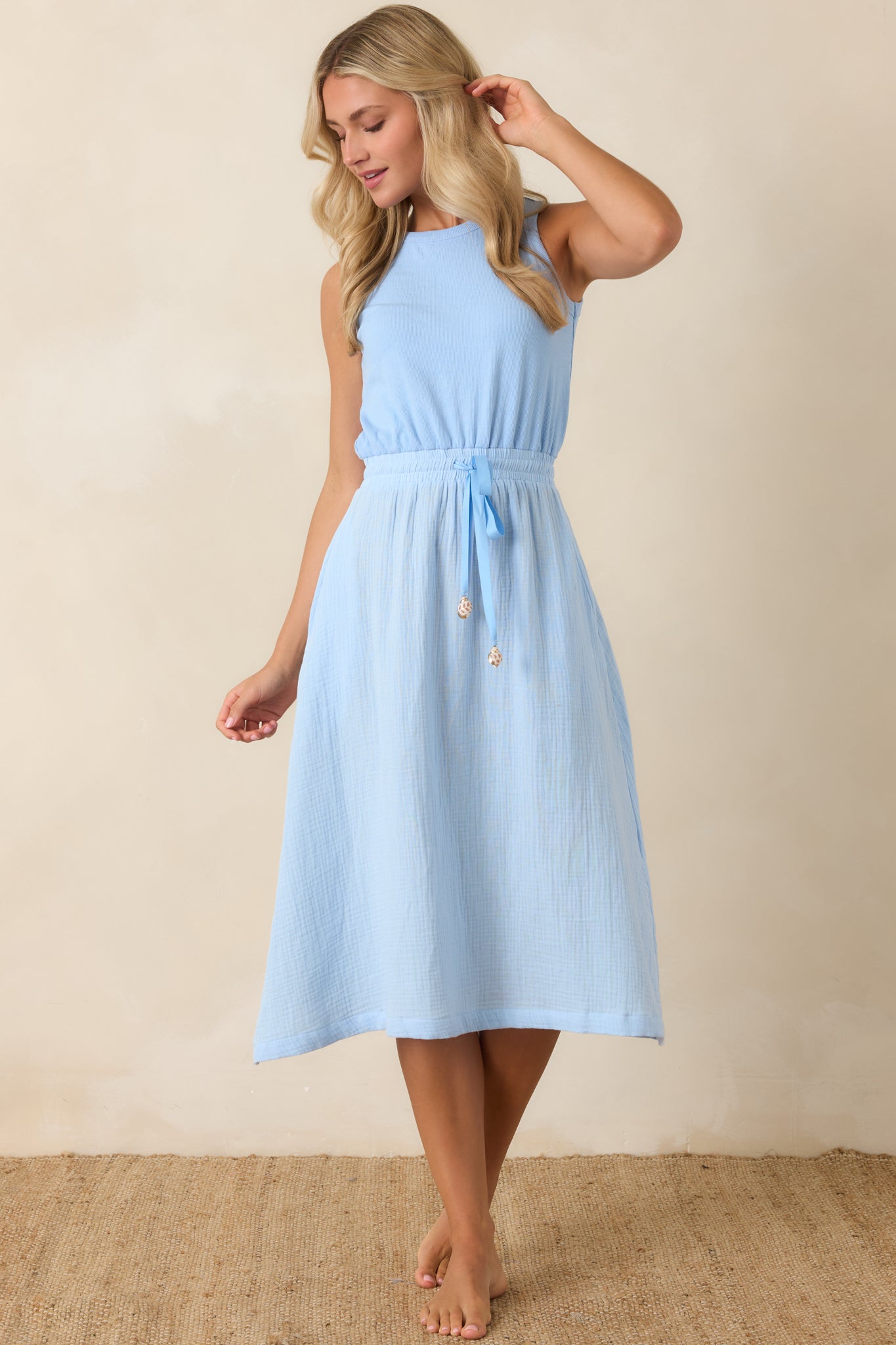 Lightweight cotton midi dress featuring subtle texture, adjustable drawstring waist, and an easy flowing silhouette.