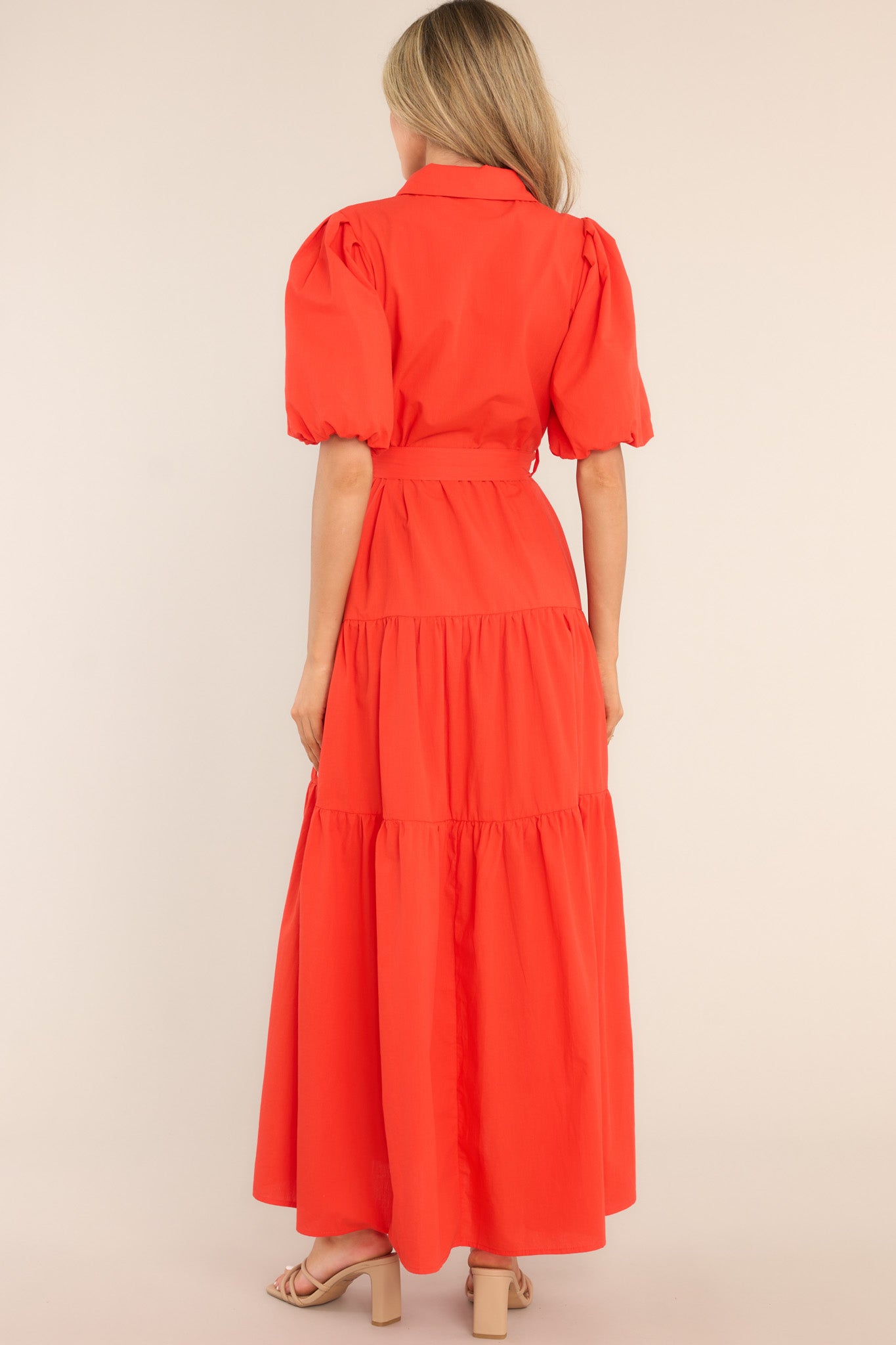 Back view of this dress that features a collared neckline, functional buttons down the front, belt loops, a self-tie belt, and short puff sleeves with elastic cuffs.
