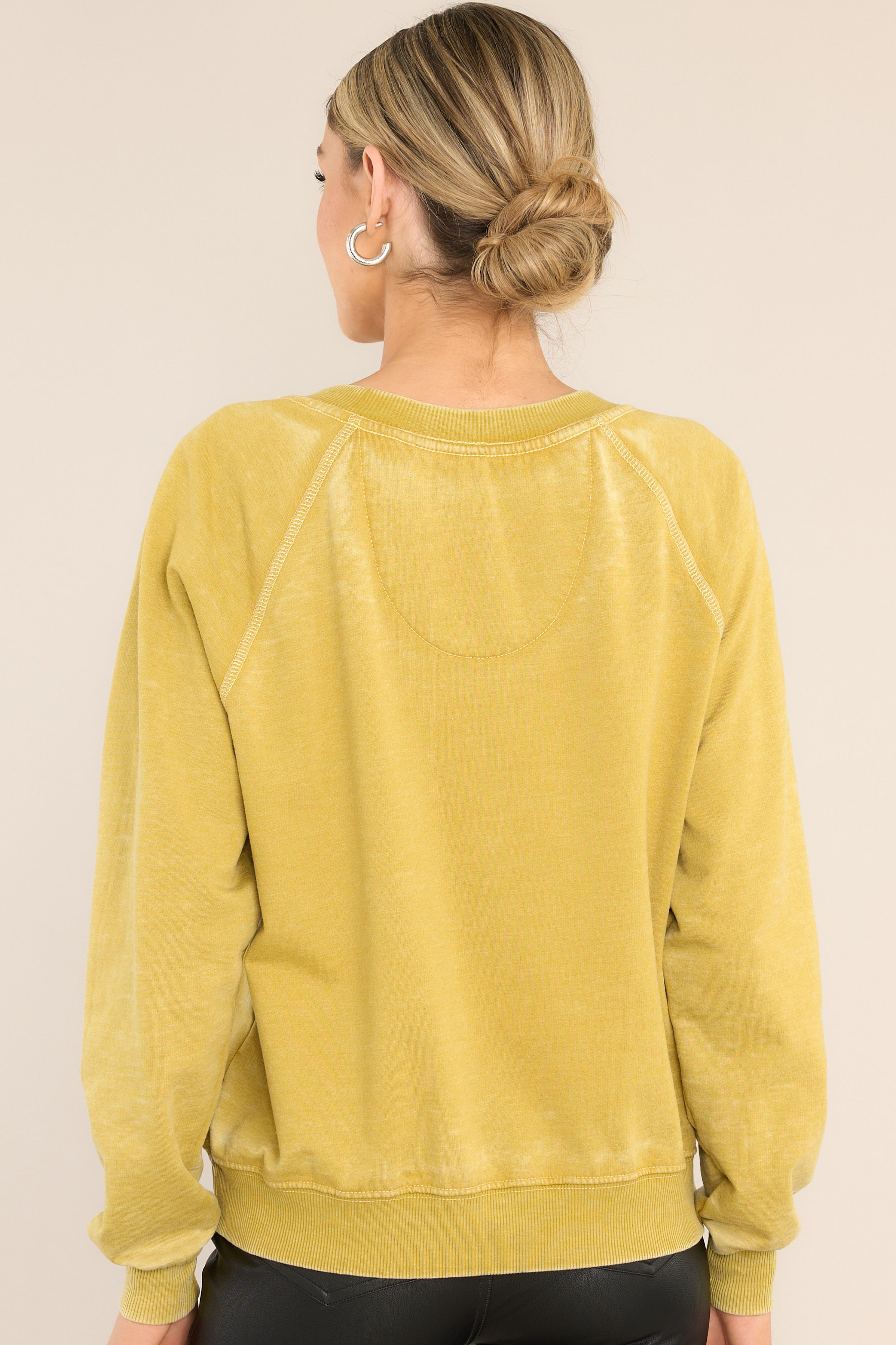 Back view of  this sweatshirt that features a ribbed crew neckline, exposed seams, graphic of the band members, 