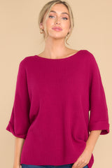 Front view of  this top that features a round neckline, quarter sleeves with cuffed arms, and a chunky knit material. 