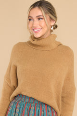 This camel colored soft sweater features a very light eyelash knit design, a turtle cowl neckline, extremely dropped shoulders, and a slight high low hemline.