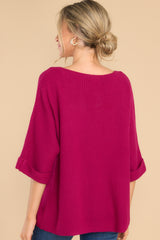 Back view of  this top that features a round neckline, quarter sleeves with cuffed arms, and a chunky knit material. 