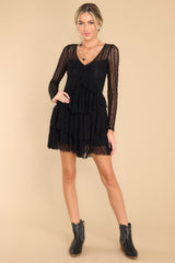 Full body view of this dress that features detailed lace fabric throughout, a v-neckline, and sheer long sleeves.