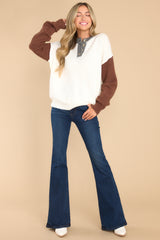 Full body view of this sweater that features a round neckline with a functional four button closure in the front, and long sleeves with tapered cuffs.