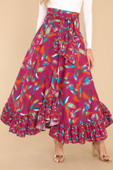 This purple maxi skirt doubles as a strapless dress with smocked side panels, an adjustable self-tie bow around the waistband/bust, a flowy skirt, an uneven hemline, and a vibrant pattern throughout.