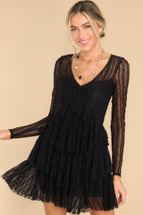 Front view of this dress that features detailed lace fabric throughout, a v-neckline, and sheer long sleeves.