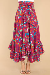 Front view of this maxi skirt that doubles as a strapless dress with smocked side panels, an adjustable self-tie bow around the waistband/bust, a flowy skirt, an uneven hemline, and a vibrant pattern throughout.