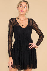 This all black  dress features detailed lace fabric throughout, a v-neckline, and sheer long sleeves. 