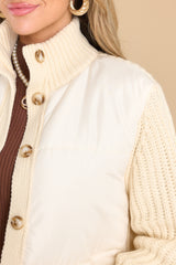 Close up view of this coat that features a turtle neckline and functional buttons down the front.
