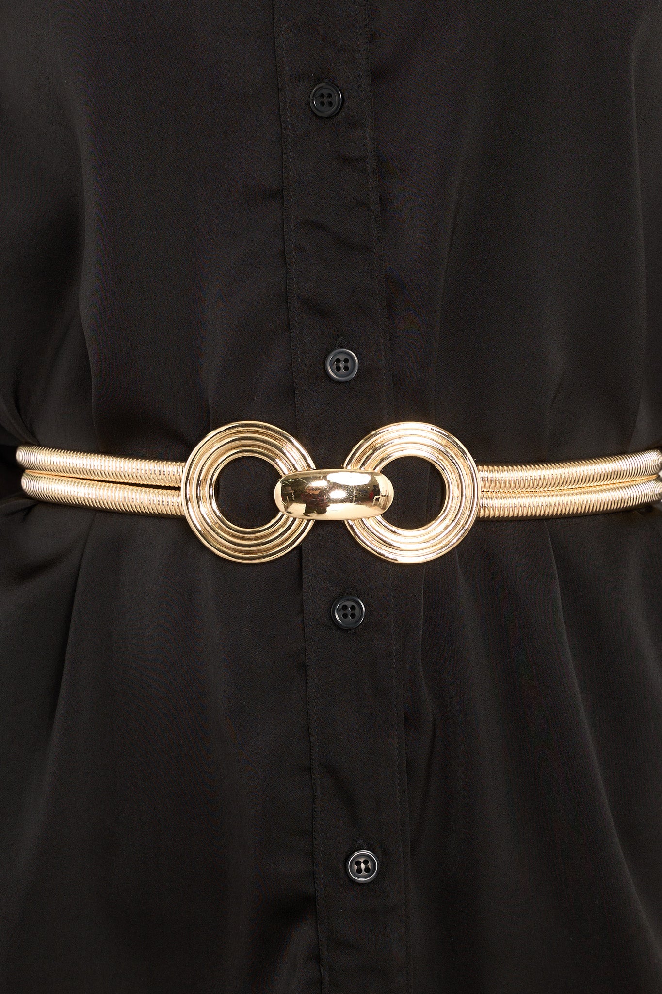 Close up view of gold belt featuring a slightly stretchy gold snake chain link design, circle detailing at the center, and a hook closure.