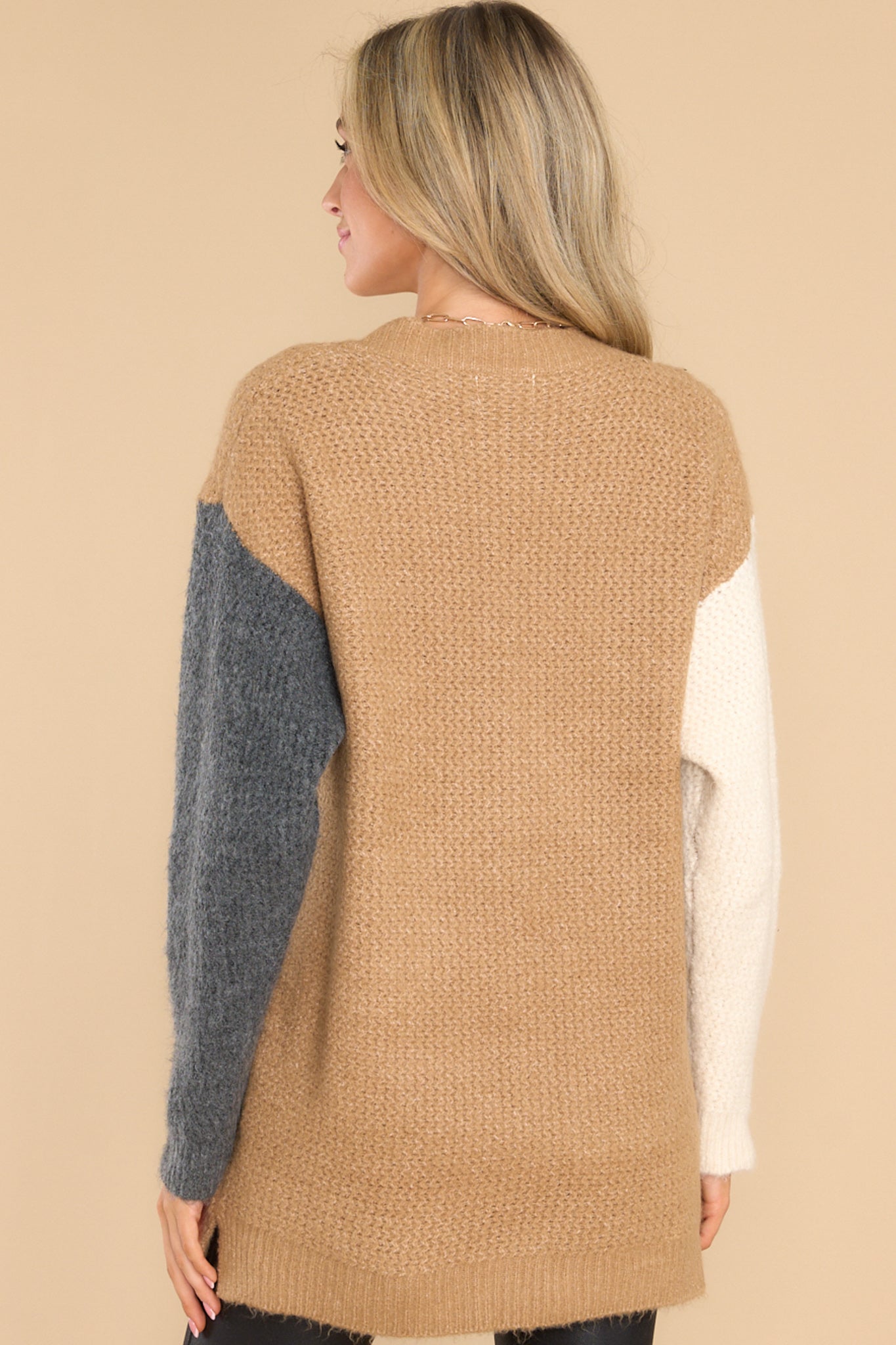 Back view of this sweater that features a v-neckline, color block design, and an oversized fit.