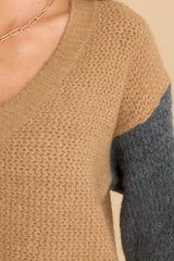 Close up view of this sweater that features a ribbed neckline and soft knit pattern throughout.