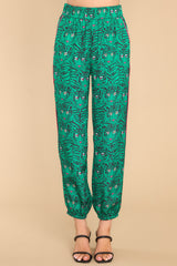Front view of these pants that feature a high waisted design, an elastic waistband, functional pockets, an abstract print, and elastic cuffed ankles.