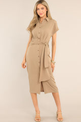 This all tan dress features a collared neckline, a full button front, a self-tie detail at the waist for achieving the perfect fit, and a front slit.