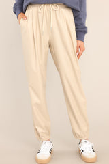 These all beige pants feature two functional pockets, adjustable drawstring waist, and elastic cuffs at the ankles.