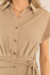 Close up view of this dress that features a collared neckline, a full button front, a self-tie detail at the waist for achieving the perfect fit, and a front slit.