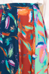 Close up view of this skirt that features a hook and zipper closure, boldly patterned panels, and a flowy skirt.