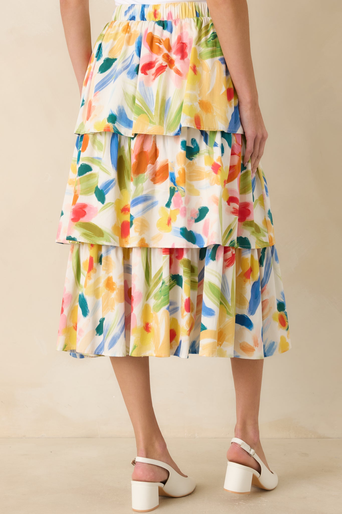 Rear view of the multicolored midi skirt showing the elastic waistband, tiered silhouette, and abstract floral print.