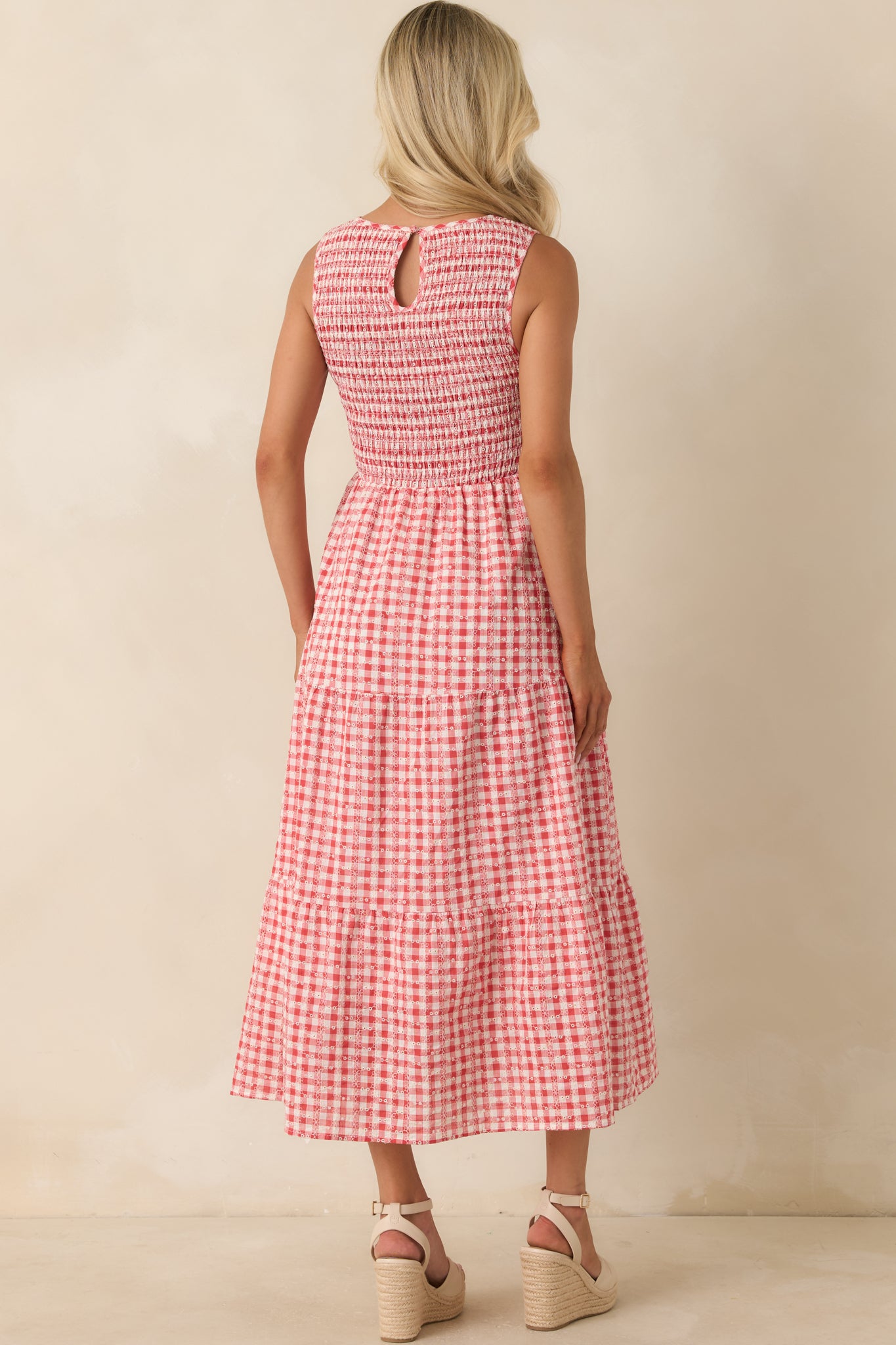 Rear view of red gingham midi dress featuring a back keyhole button closure and tiered skirt silhouette.